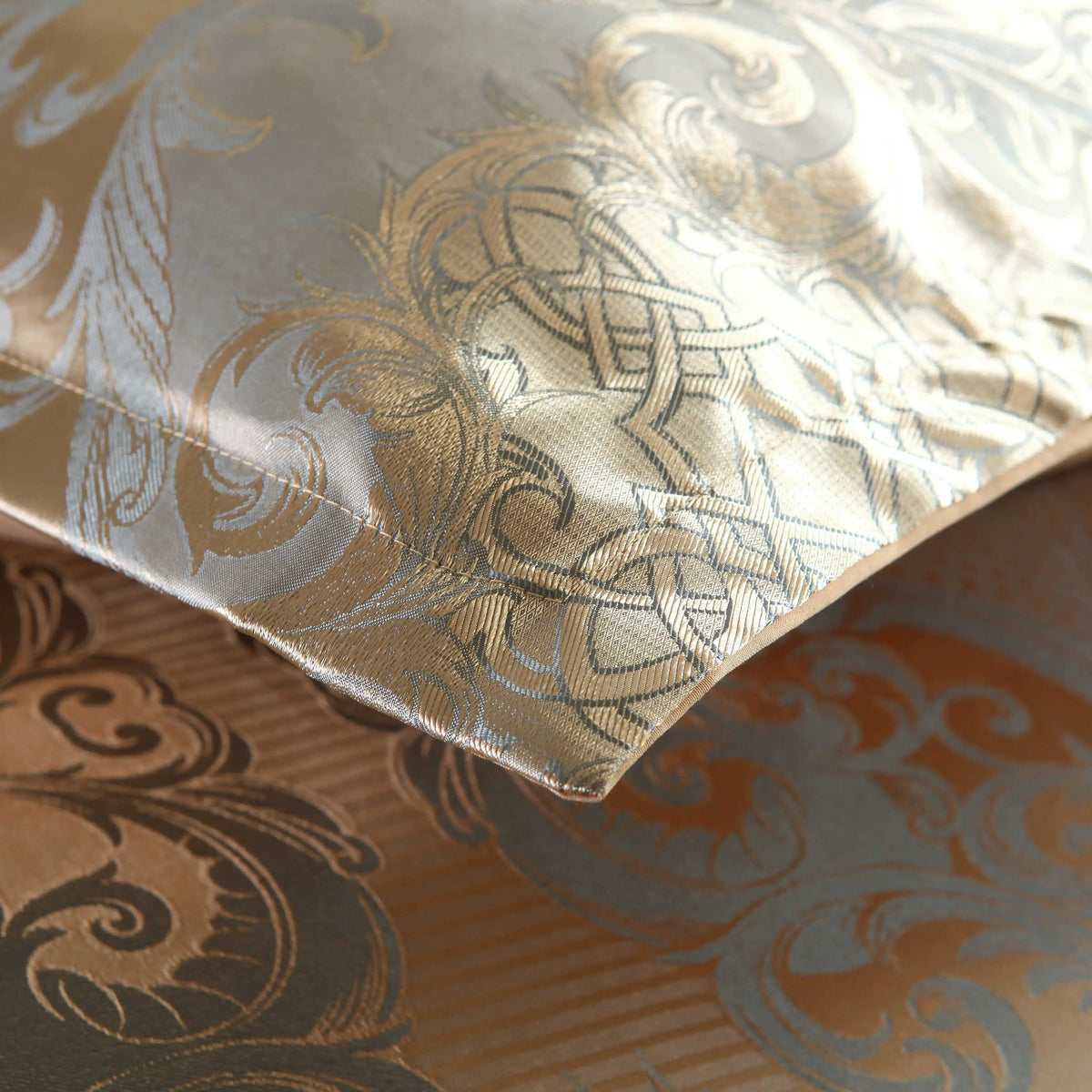 Gros plan sur le coin d'une housse de couette en satin damassé doré à motifs d'arabesques gris