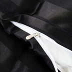 Gros plan sur la fermeture éclair d'une housse de couette en satin noir à rayures, intérieur blanc