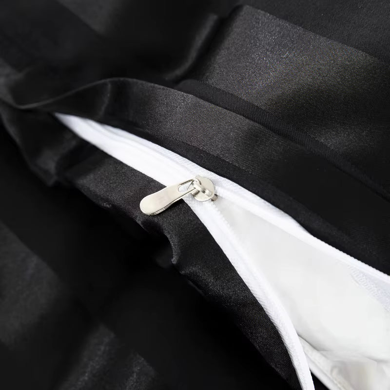 Gros plan sur la fermeture éclair d'une housse de couette en satin noir à rayures, intérieur blanc
