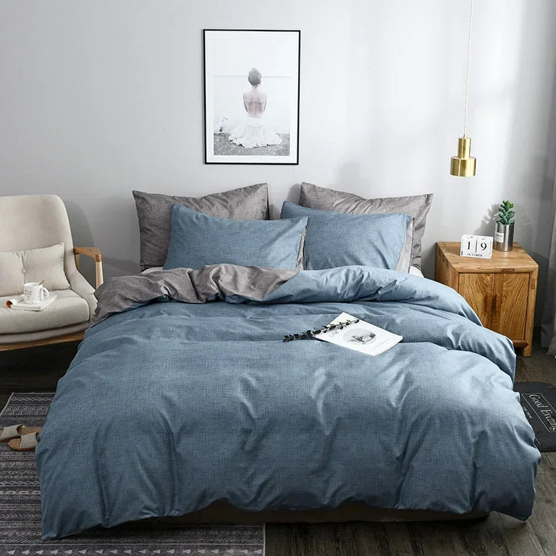 Housse de couette bleu chiné avec revers gris, sur un lit avec taies d'oreiller assorties