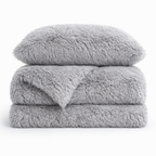Housse de couette effet fourrure gris clair à poils longs pliée, avec taie d'oreiller assortie