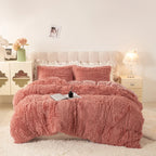 Housse de couette effet fourrure vieux rose à poils longs sur un lit, avec taies assorties