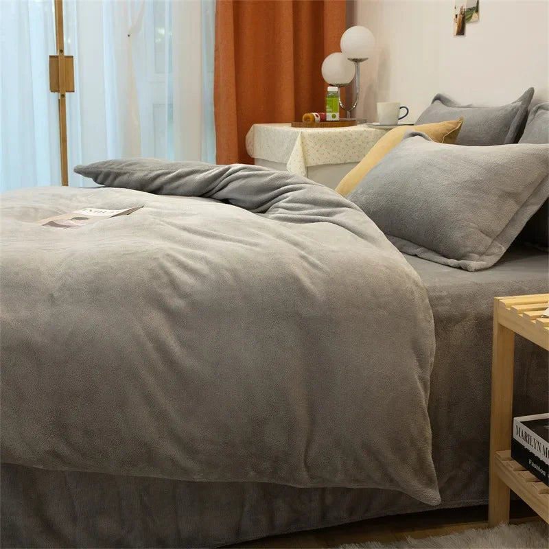 Housse de couette en flanelle gris clair unie sur un lit, avec taies d'oreiller grises assorties