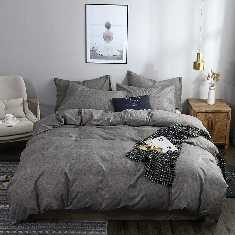Housse de couette gris chiné sur un lit, avec taies d'oreiller grises assorties, vue de face