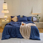 Housse de couette et taies d'oreiller en percale de coton bleu marine sur un lit, vue de face