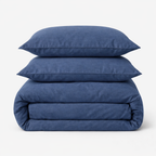 Housse de couette en percale de coton bleu marine pliée avec deux taies d'oreiller assorties