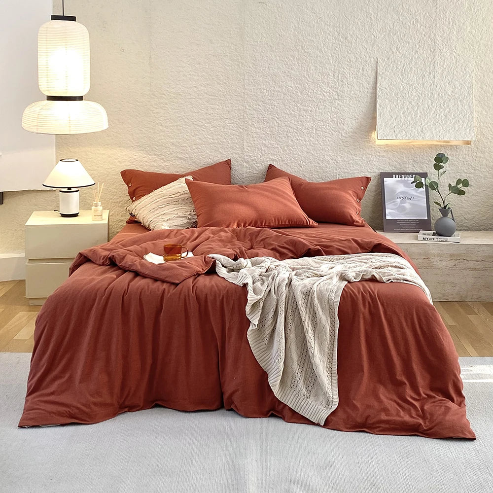 Housse de couette et taies d'oreiller en percale de coton terracotta sur un lit, vue de face