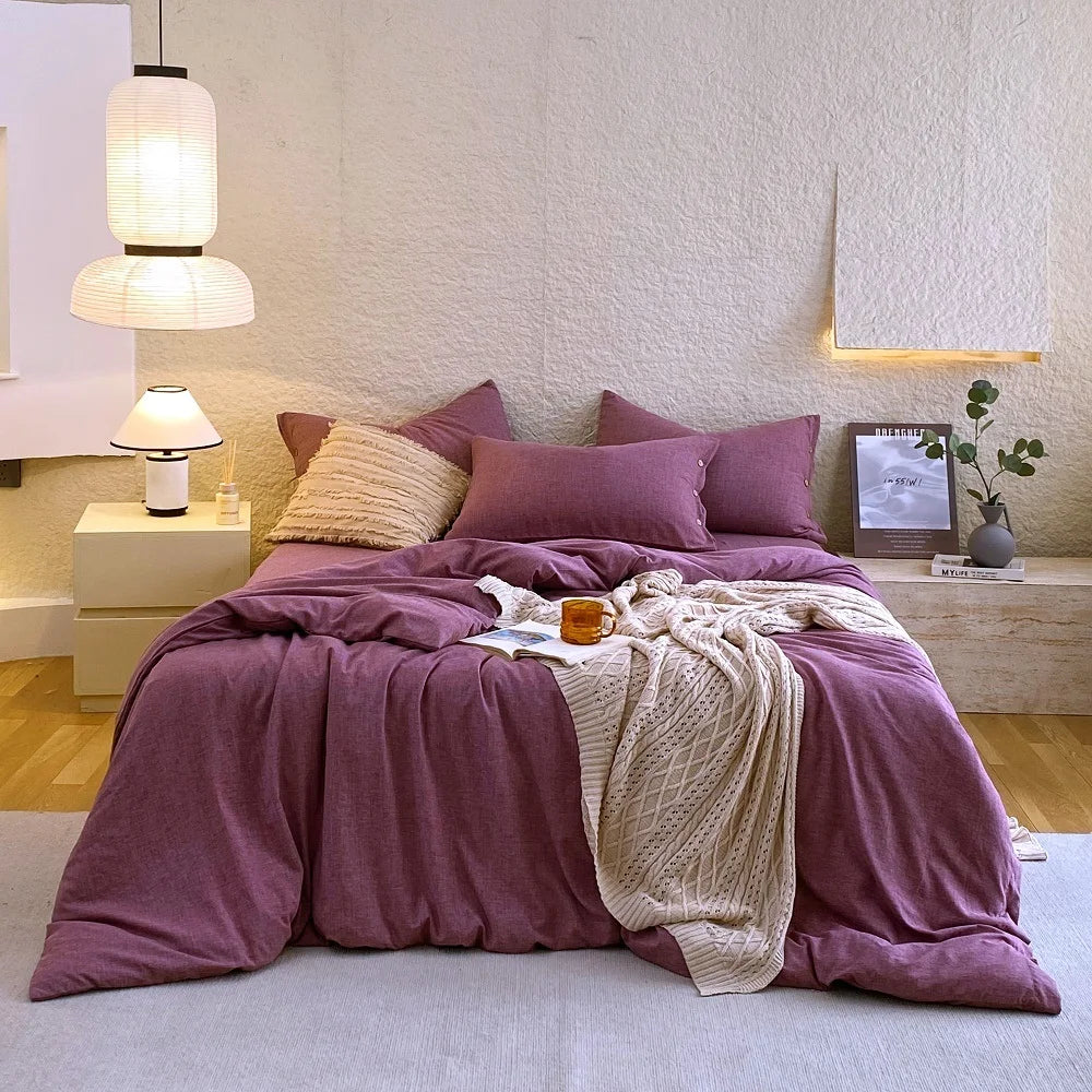 Housse de couette et taies d'oreiller en percale de coton violet raisin sur un lit, vue de face