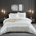 Housse de couette en satin blanc à rayures ton sur ton sur un lit, vue de face avec taies assorties