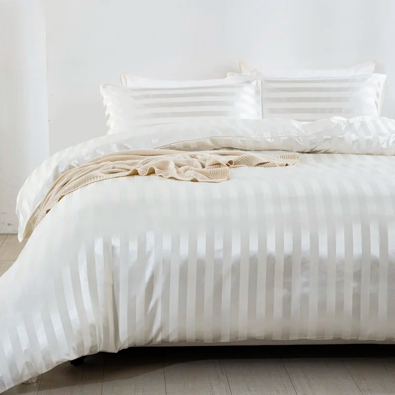 Housse de couette en satin blanc à rayures ton sur ton sur un lit, vue rapprochée avec taies