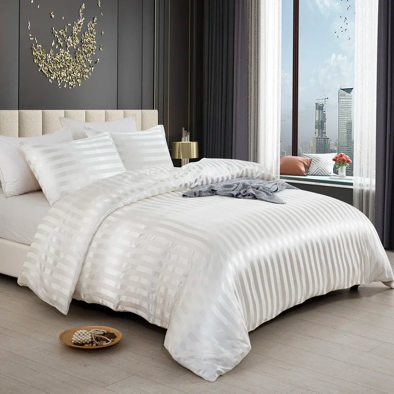 Housse de couette en satin blanc à rayures ton sur ton sur un lit, vue de trois quarts avec taies