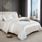 Housse de couette en satin blanc à rayures ton sur ton sur un lit, vue de trois quarts avec taies