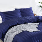 Vue rapprochée d'une housse de couette et de taies en satin bleu marine à rayures ton sur ton