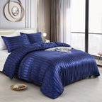 Housse de couette en satin bleu marine à rayures sur un lit, vue de trois quarts avec taies