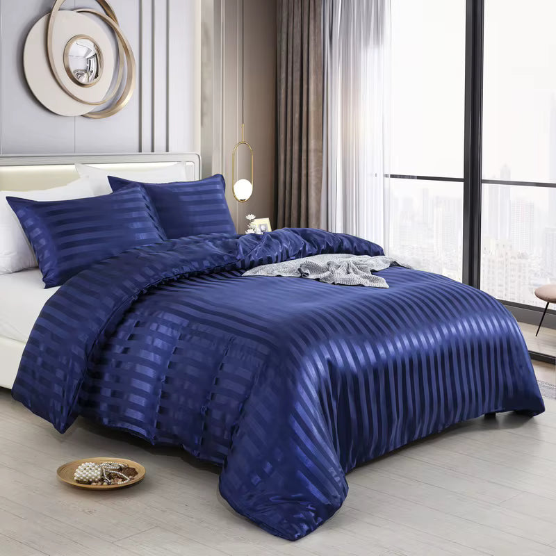 Housse de couette en satin bleu marine à rayures sur un lit, vue de trois quarts avec taies