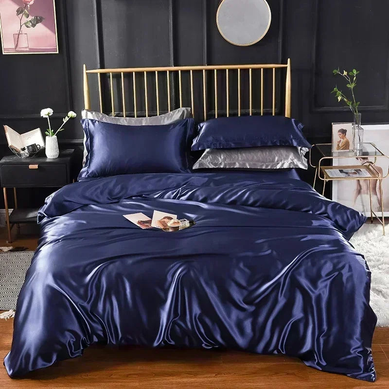 Housse de couette en satin bleu nuit sur un lit, avec taies bleu nuit et taies grises assorties