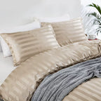 Vue rapprochée d'une housse de couette et de taies en satin beige champagne à rayures ton sur ton