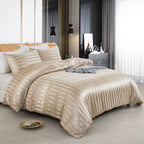 Housse de couette en satin beige champagne à rayures sur un lit, vue de trois quarts avec taies