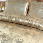 Vue rapprochée d'une housse de couette et de taies en satin damassé doré à arabesques gris bleuté