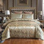 Housse de couette en satin damassé doré et gris bleuté sur un lit, vue de face avec taies assorties