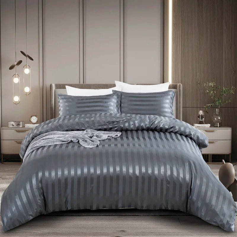 Housse de couette en satin gris anthracite à rayures ton sur ton sur un lit, vue de face avec taies