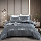 Housse de couette en satin gris anthracite à rayures ton sur ton sur un lit, vue de face avec taies