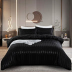 Housse de couette en satin noir à rayures ton sur ton sur un lit, vue de face avec taies assorties