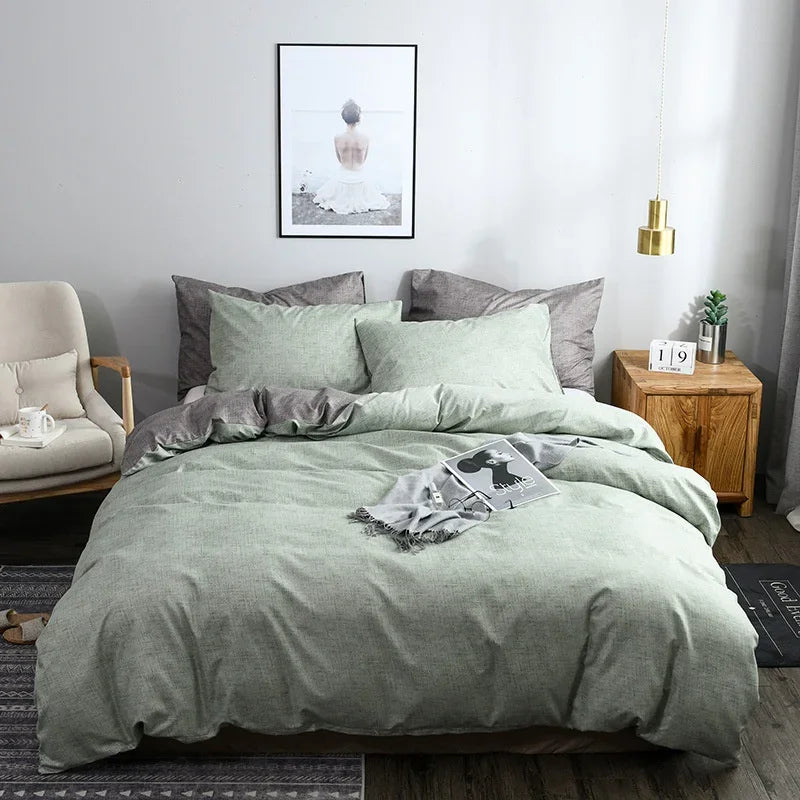 Housse de couette vert clair chiné avec revers gris, sur un lit avec taies d'oreiller assorties