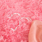 Liens d'attache blancs sur une housse de couette effet fourrure rose à poils longs, vue rapprochée