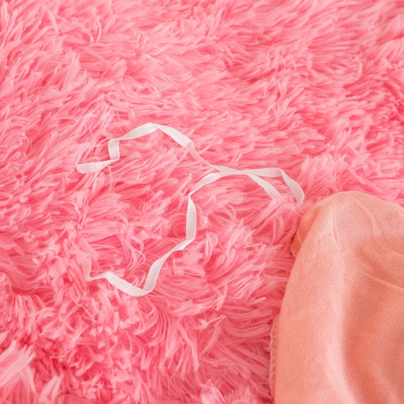 Liens d'attache blancs sur une housse de couette effet fourrure rose à poils longs, vue rapprochée