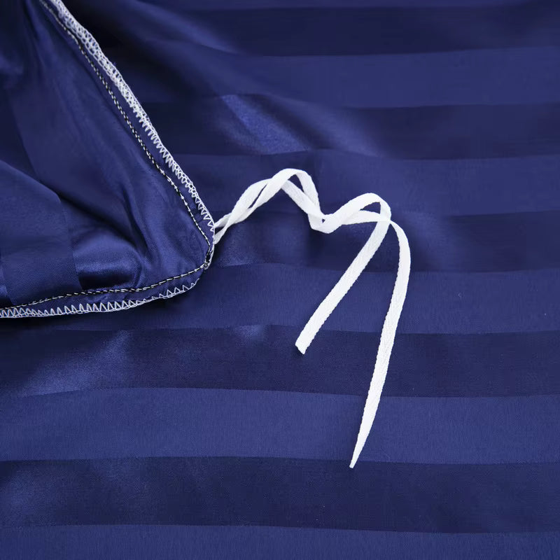 Liens d'attache blancs à l'intérieur d'une housse de couette en satin bleu marine à rayures