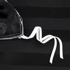Liens d'attache blancs à l'intérieur d'une housse de couette en satin noir à rayures ton sur ton