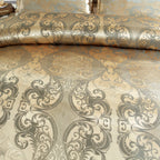 Gros plan sur le motif d'arabesques gris bleuté d'une housse de couette en satin damassé doré