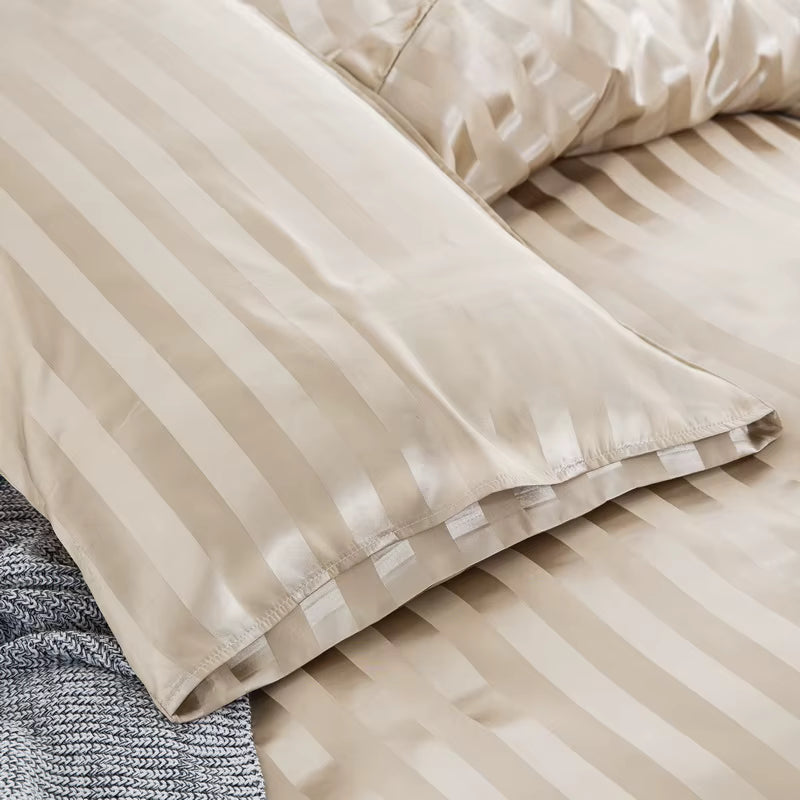 Gros plan sur le bord d'une taie d'oreiller en satin beige champagne à rayures ton sur ton