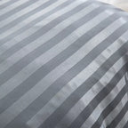 Gros plan sur les rayures brillantes et mates d'un tissu en satin gris anthracite